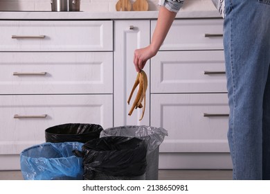 Woman Throwing Banana Peel Into Trash Bin In Kitchen, Closeup. Separate Waste Collection