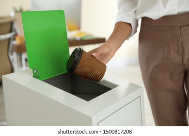 Woman Throwing Coffee Cup Into Recycling Bin At Office, Closeup