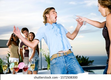 Woman Throwing Her Drink Over A Man At A Party