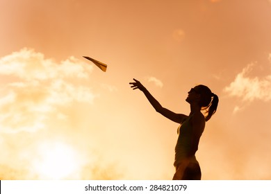 Woman Throwing Paper Airplane In A Beautiful Setting. 