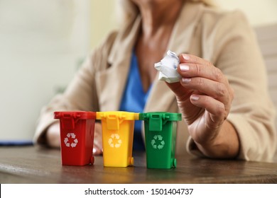 Woman Throwing Paper Into Mini Recycling Bin At Office, Closeup