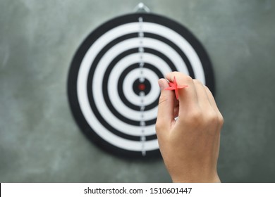 Woman throwing red arrow at dart board on grey background, closeup - Shutterstock ID 1510601447