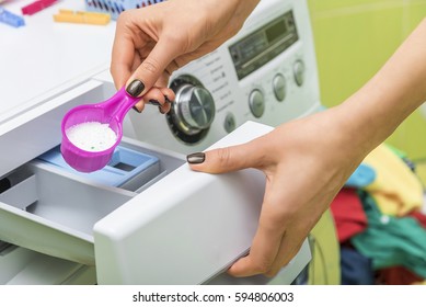 Woman Throws Laundry Detergent Into The Washing Machine Close-up.