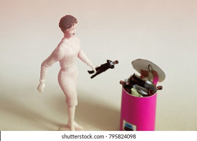 Woman Throws Tiny Man In A Trash Can.  Concept Of Ending Bad Relationships Or Ditching A Bad Boss. Breakup Or Divorce. Concept Of Employment Or Romantic Rejection. Frustration With Online Dating. 