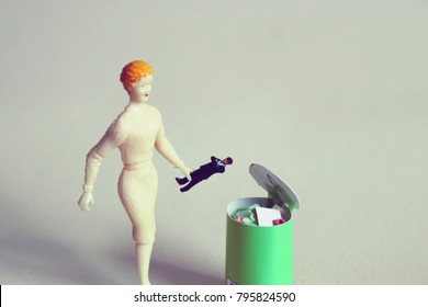 Woman Throws Tiny Man In A Trash Can.  Concept Of Ending Bad Relationships Or Ditching A Bad Boss. Breakup Or Divorce. Concept Of Employment Or Romantic Rejection. Frustration With Online Dating. 