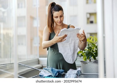 A Woman Is Tidying Up A Messy House. A Thoughtful Young Woman With A Ponytail Neatly Prepared Dry And Clean Laundry During The Day On The Terrace. House Cleaning, Housekeeping, House Chores