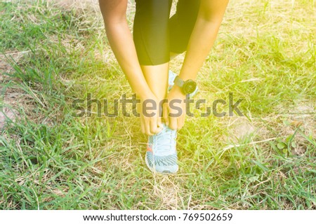 woman tie her shoes in the park