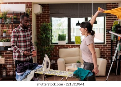 Woman Tired Of Doing All The Chores At Home Without Help While Husband Is Distracted By Cell Phone. African American Man Trying To Communicate With His Wife And Solve Problems By Talking.