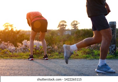 woman tired on running jogging exercise by hand resting on the knees, workout running of woman unfit and tired often