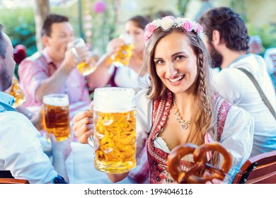 Woman Toasting To The Camera With Glass Of Beer In Bavarian Pub