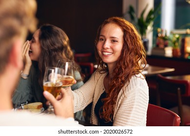 Woman toasting wine at dinner