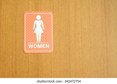 Woman Toilets Sign For Public Restroom On A Wood Wall.