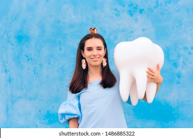 Woman In Tooth Fairy Costume Holding Big Molar. Funny Princess Holding An Oversized Fallen Baby Tooth 
