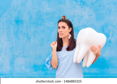 Woman In Tooth Fairy Costume Holding Big Molar. Funny Princess Holding An Oversized Fallen Baby Tooth 
