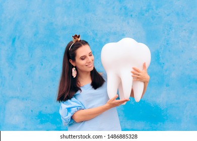 Woman In Tooth Fairy Costume Holding Big Molar. Funny Princess Holding An Oversized Fallen Baby Tooth 
