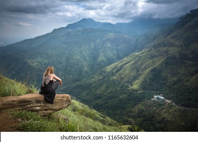 Woman at the top of little Adam's Peak on a cloudy day of february in Ella, Sri Lanka - Shutterstock ID 1165632604