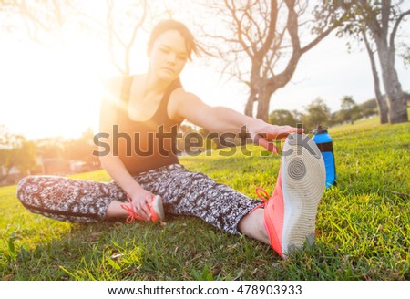 Woman touches toes while stretching outdoors