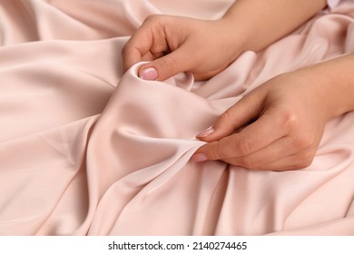 Woman touching delicate beige fabric, closeup view - Shutterstock ID 2140274465