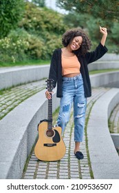 Woman Touching Guitar Standing In Park During Day