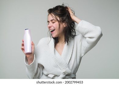 Woman touching her hair. Woman hold bottle shampoo and conditioner. Happy young woman with balm bottle applying hair mask. Beauty product. - Shutterstock ID 2002799453