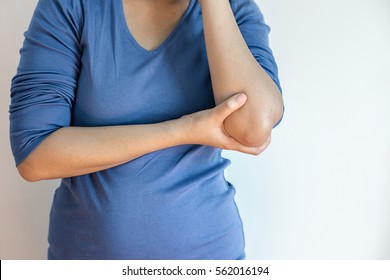 Woman touching her painful elbow - Shutterstock ID 562016194