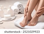 Woman touching her smooth feet on floor, closeup. Body care