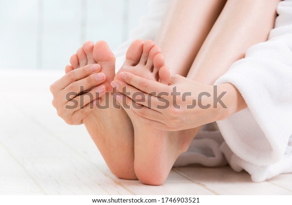 A woman is touching her\
sole.