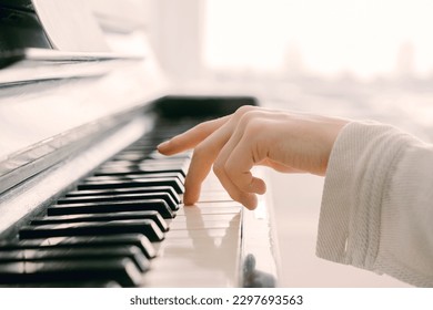 a woman touching piano key with left hand - Powered by Shutterstock