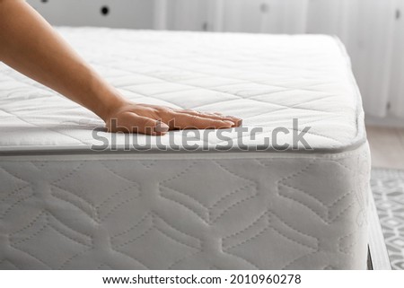 Woman touching soft orthopedic mattress
