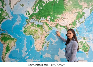 Woman touching world map looking at camera, geography - Powered by Shutterstock