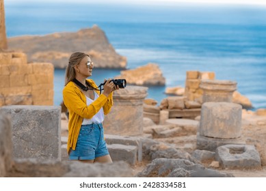 A woman tourist with a camera in the Acropolis on an excursion. - Powered by Shutterstock