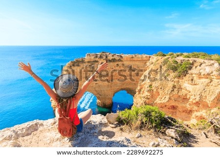 Woman tourist enjoying panoramic view of beautiful algarve heart shaped cliff on atlantic ocean- travel destination, summer vacation travel concept- Portugal ( praia da Marinha, carvoeiro, benagil)