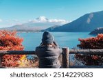 Woman tourist with Fuji Mountain at Lake Motosu in Autumn season, happy Traveler travel Mount Fuji, Yamanashi, Japan. Landmark for tourists attraction. Japan Travel, Destination and Vacation