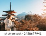 Woman tourist with mount Fuji at Chureito Pagoda in Autumn season, Traveler travel Arakurayama Sengen Park, Yamanashi, Japan. Landmark for tourist attraction. Japan Travel, Destination and Vacation