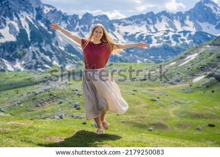 Woman tourist in Mountain lake landscape on Durmitor mountain in Montenegro beautiful Durmitor National park with lake glacier and reflecting mountain