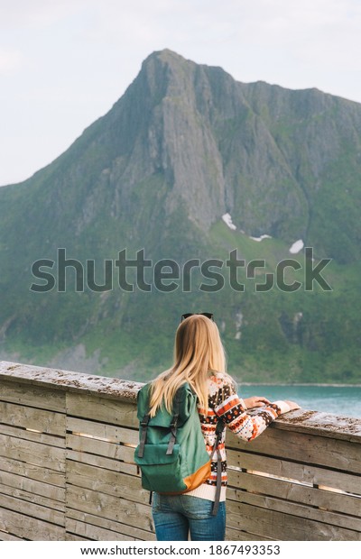 Woman tourist sightseeing looking at view\
in Norway solo travel backpacking active healthy lifestyle outdoor\
eco tourism summer vacation tour\
