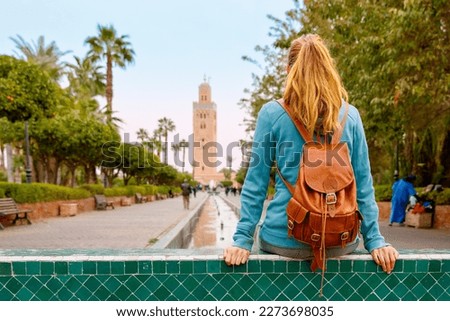 Woman tourist sitting and looking at Koutoubia mosque in Marrakesh, Morocco Stock foto © 