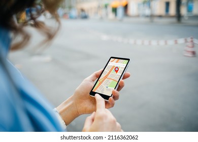 Woman tourist use maps app to navigate city, plan route from location to destination - Shutterstock ID 2116362062