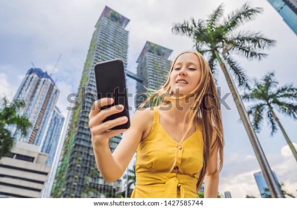 Woman Tourist using navigation\
app on the mobile phone. Navigation map on a smartphone in a big\
city