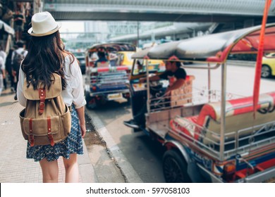 Woman Tourist Walking In Busy Bangkok Street On Thailand Travel. Asian Girl On Street During Asia Summer Vacation. Thai Traditional Taxi Tuk Tuk Car.