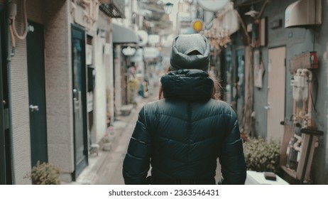 Woman tourist walking small city street in Tokyo. Caucasian girl enjoy backstreet alley with old restaurants, pubs, drinking bars. Golden Gai Street, Japanese. Back view slow motion. Travel, tourism - Powered by Shutterstock