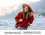 Woman tourist walks along the embankment in cold weather. The concept of travel, vacation. Active lifestyle.