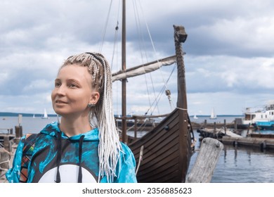 woman tourist went ashore after sailing in a modern replica of anсient viking longship - Shutterstock ID 2356885623