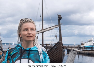 woman tourist went ashore after sailing in a modern replica of anсient viking longship - Shutterstock ID 2357878559