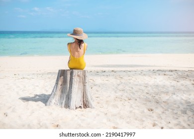 Woman tourist in yellow swimsuit and hat, solo traveller looking beautiful sea view at bamboo island on Phi Phi don island, Krabi, Thailand. destination, summer Travel, vacation and holiday concept
