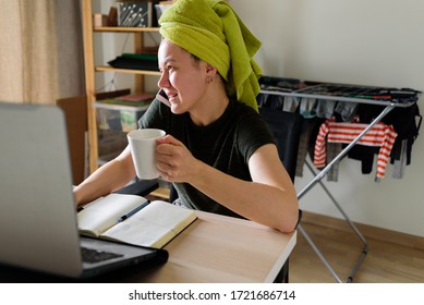 Woman With A Towel On Her Head Working On Laptop From Home. Real Life, Office In Bedroom