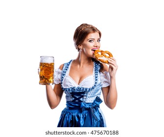 Woman in traditional bavarian dress holding beer and pretzel