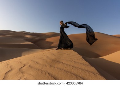 Woman with a traditional Emirati dress in desert.