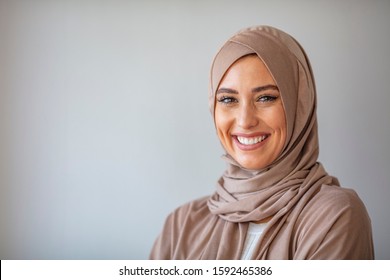 Woman in traditional Muslim clothing, smiling. Beautiful woman headshot looking at camera and wearing a hijab. Arabian woman with happy smile. Strict formal outfit and elegant appearance. Islamic - Powered by Shutterstock