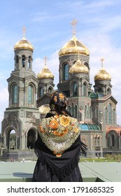Woman in traditional national folk Pavlovo Posad shawl, scarf. Resurrection of Christ Cathedral, main cathedral of Russian Armed Forces in Moscow city, Russia. Orthodox Church. Architectural fashion